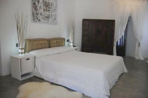 1 dormitorio con 2 camas blancas y TV en Apartamento El Cuarton, en Tarifa
