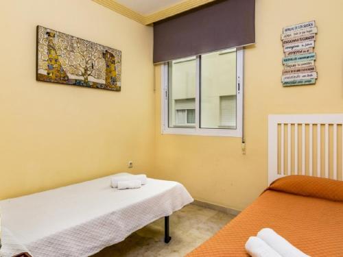 マルベーリャにあるApartamento 358のベッド2台と窓が備わる客室です。