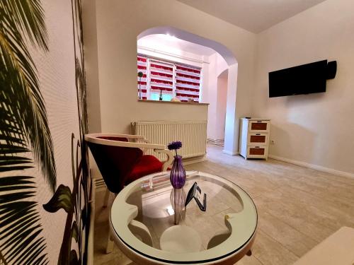 sala de estar con mesa de cristal y silla en Apartament Faleza, en Galaţi