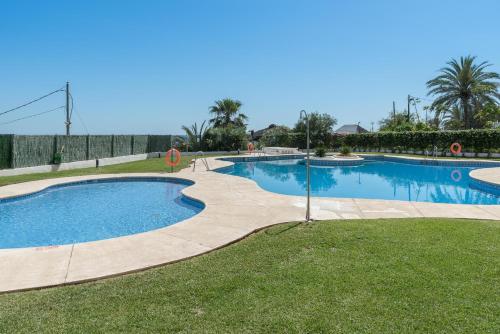 una gran piscina en un patio con césped en Apartamento 341, en Marbella