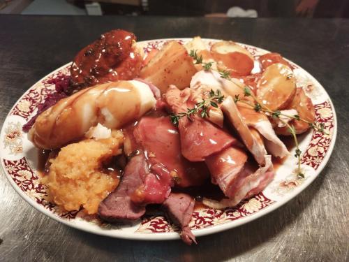 a plate of food with meat and vegetables on a table at Trawden Arms Community Owned Pub in Winewall