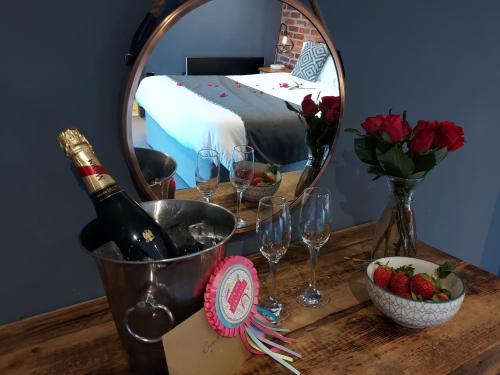 a table with a bottle of wine and a mirror at Trawden Arms Community Owned Pub in Winewall