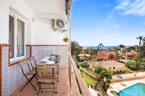 a balcony with a table and chairs and a view of the ocean at Cozy estudio in Benalmádena in Benalmádena