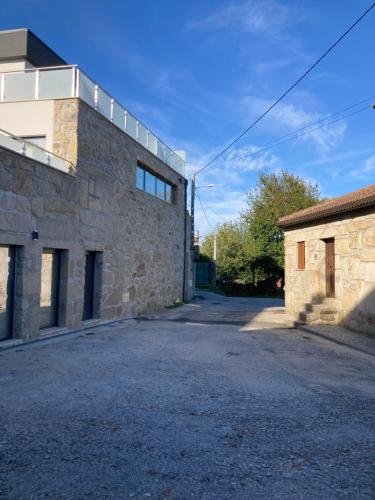 an empty parking lot next to a stone building at CASA DA TECEDEIRA in Carvalhais