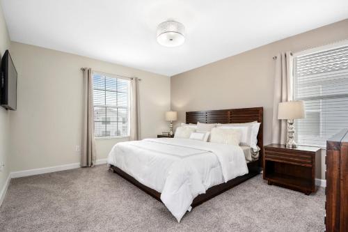 - une chambre blanche avec un grand lit et des fenêtres dans l'établissement 5Br 5Bath Pvt Home BBQ Pool 10min Disney 3077ft, à Kissimmee