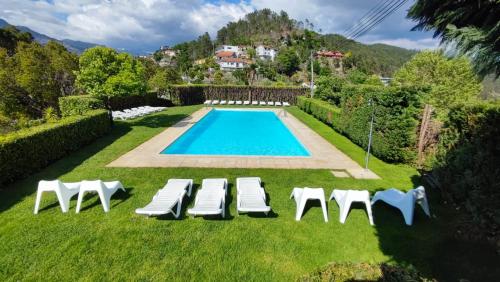 a swimming pool with lawn chairs and a swimming pool at Verde Pinho in Geres