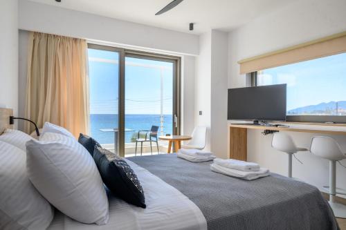 a bedroom with a bed with a view of the ocean at CUBES ON THE BEACH Athens Airport in Artemida