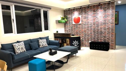 a living room with a blue couch and a brick wall at Penghu Little Apple II in T'ien-hsiang