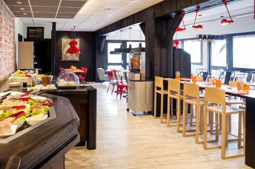 a restaurant with a buffet line with tables and chairs at ibis Styles Chartres Métropole in Chartres