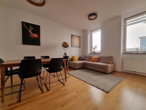 uma sala de estar com uma mesa e cadeiras e um sofá em Vienna Experience em Viena