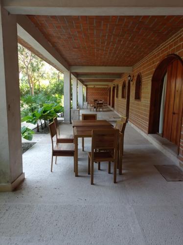 a porch with a wooden table and chairs on a patio at Hotel Casa de Lirio Diamante in Acapulco