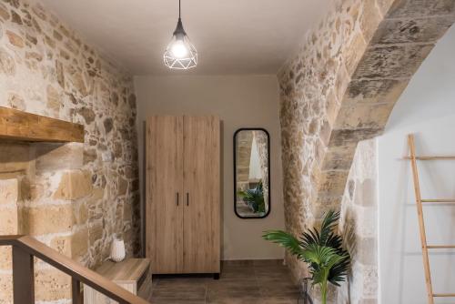 a hallway with a stone wall and a mirror at Dinas's Cottage Ideal Base for Balos and Elafonisi in Kaloudhianá
