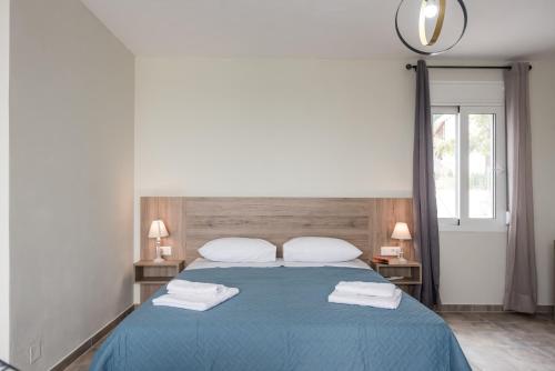 a bedroom with a blue bed with two towels on it at Dinas's Cottage Ideal Base for Balos and Elafonisi in Kaloudhianá