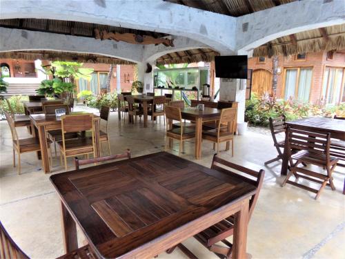 a dining room with wooden tables and chairs at Hotel Casa de Lirio Diamante in Acapulco