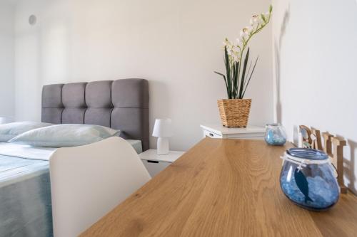 a bedroom with a bed and a wooden table with a vase at Penthouse Gea in Premantura