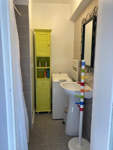 a bathroom with a sink and a yellow door at Calme et spacieux près du Loing et du centre in Moret-sur-Loing