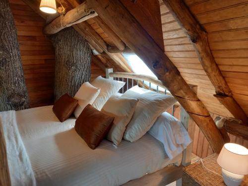 ein Schlafzimmer mit einem Bett in einem Blockhaus in der Unterkunft Cabane suspendue dans les arbres in Villebon-sur-Yvette