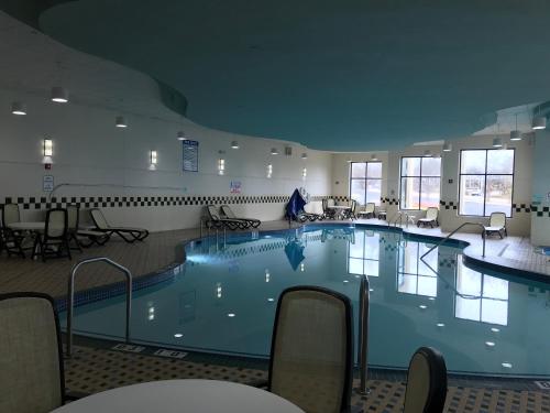 a large swimming pool in a room with tables and chairs at Holiday Inn Hotel & Suites Chicago Northwest - Elgin by IHG in Elgin
