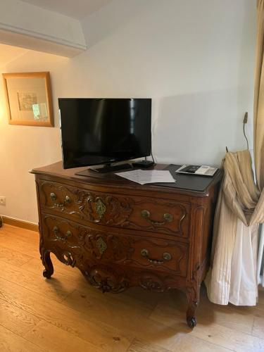 a wooden dresser with a television on top of it at Face au Palais in Avignon