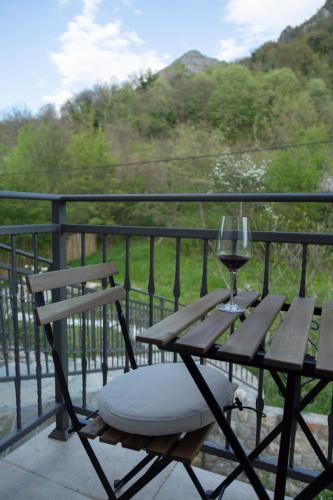 a wooden table with a glass of wine on a balcony at Plamenatz studio apartments in Virpazar