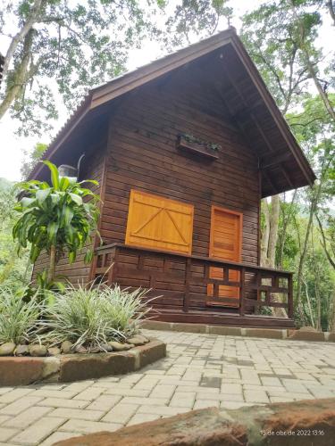 a log cabin with a patio in front of it at Cabanas dos Plátanos in Gramado