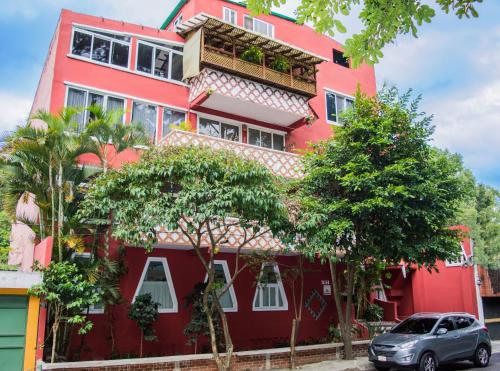 a red building with a car parked in front of it at Eco Suites Uxlabil Guatemala in Guatemala