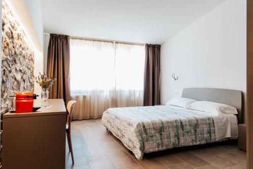 a bedroom with a bed and a desk and a window at LA RIPA in Riomaggiore