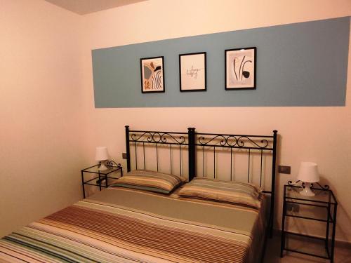 - une chambre dotée d'un lit avec 3 photos sur le mur dans l'établissement B&B La Mimosa, à Castro di Lecce