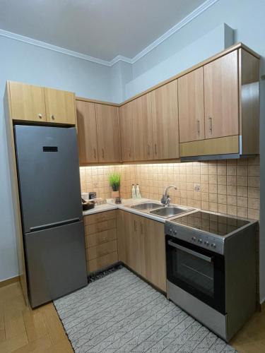 a kitchen with wooden cabinets and a stainless steel refrigerator at Nemeapolis 3 apt in Neméa