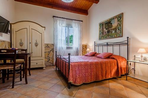 a bedroom with a bed and a table and a desk at Valleforno Country House di Charme in Ispica