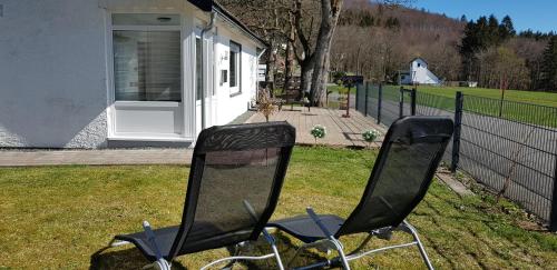 deux chaises assises dans l'herbe près d'une clôture dans l'établissement Villa Winterberg Mollseifen, à Winterberg