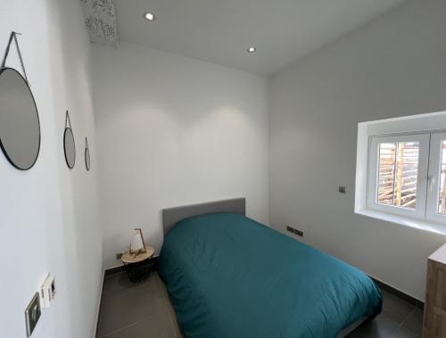 Un dormitorio con una cama verde en una habitación blanca en LE LOFT - 70m2 T3 Cronenbourg 6 pers, en Estrasburgo