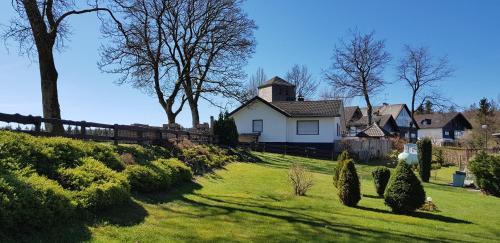 a yard with a white house and a fence at Villa Winterberg Mollseifen in Winterberg