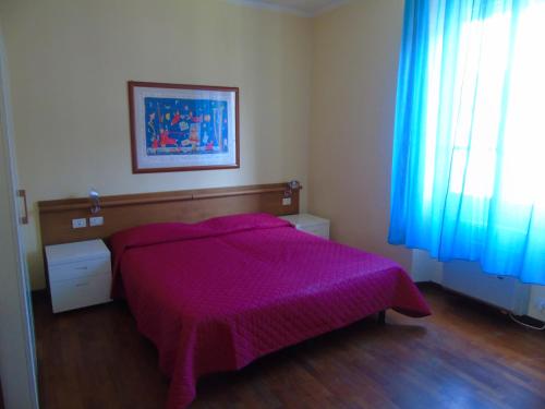 a bedroom with a bed with a purple blanket at Affittacamere Bel Sole in Borghetto di Vara
