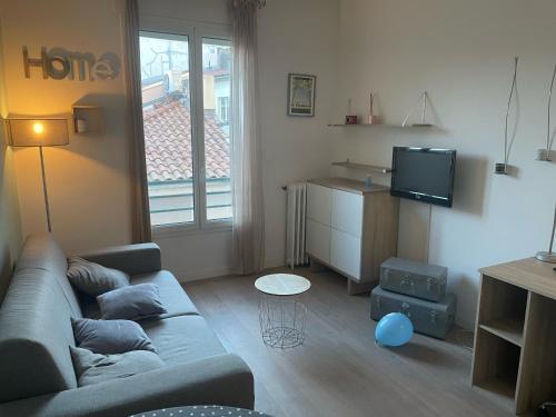 a living room with a couch and a tv at Studio Magenta in Nice