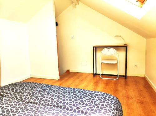a bedroom with a bed and a chair in it at Le 3plex - Coeur de Vertou - Original in Vertou