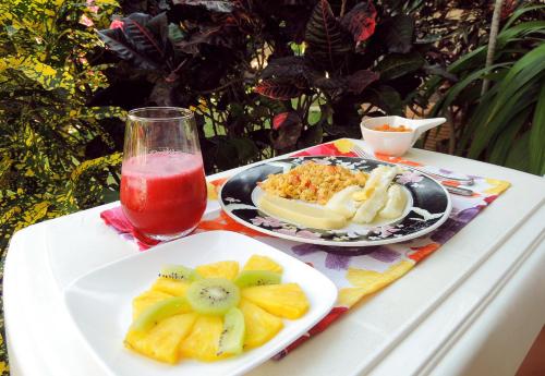 a table with a plate of fruit and a drink at Portoazul Casa de Playa in Puerto Colombia