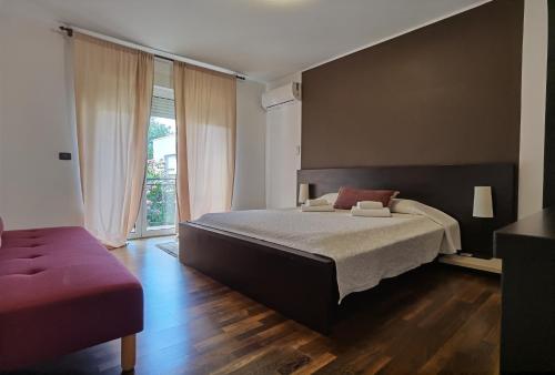 sypialnia z dużym łóżkiem i dużym oknem w obiekcie Pine and Lime Apartments w Puli