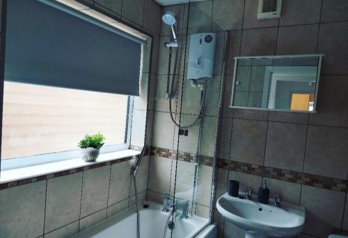 a bathroom with a shower and a sink and a tub and a mirror at The Stone House II in Nottingham