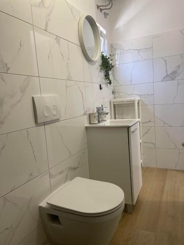a white bathroom with a toilet and a mirror at Apartman's M4 Stay by the Sea Kali in Kali