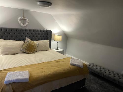 ein Schlafzimmer mit einem großen Bett und einer Lampe in der Unterkunft Commercial Hotel (Insch) in Insch