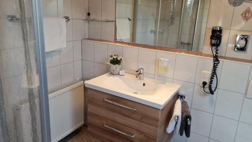 W łazience znajduje się umywalka i lustro. w obiekcie Ferienhof Rindler w mieście Schlaiten