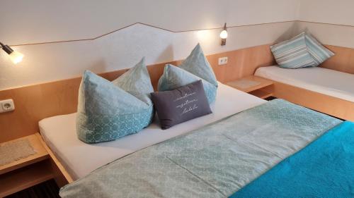 Un par de almohadas sentadas en una cama en un barco en Ferienhof Rindler, en Schlaiten