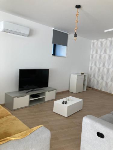 a living room with a flat screen tv and a couch at CASA DA TECEDEIRA in Carvalhais