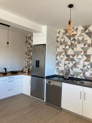 a kitchen with white cabinets and stainless steel appliances at CASA DA TECEDEIRA in Carvalhais