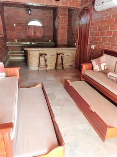 a living room with two beds and a bar at Hotel Casa de Lirio Diamante in Acapulco