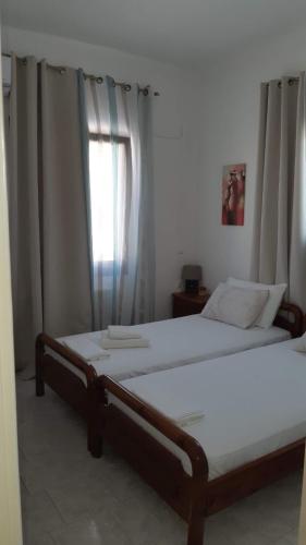 a bedroom with two beds and a window at Ενάλιον in Astypalaia