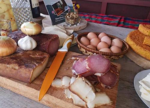 a cutting board with meat and eggs on a table at Household Babovic - Old house Miljan's valley in Andrijevica
