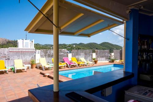 eine Terrasse mit Stühlen und einem Pool in der Unterkunft Hostal Ferrer in Sant Antoni de Portmany