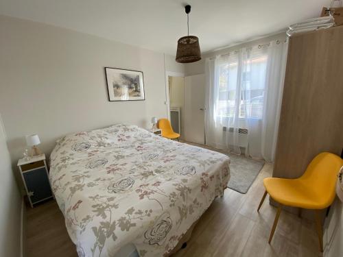 - une chambre avec un lit, deux chaises et une fenêtre dans l'établissement « Heures claires » logement de charme avec parking, à Saint-Georges-de-Didonne